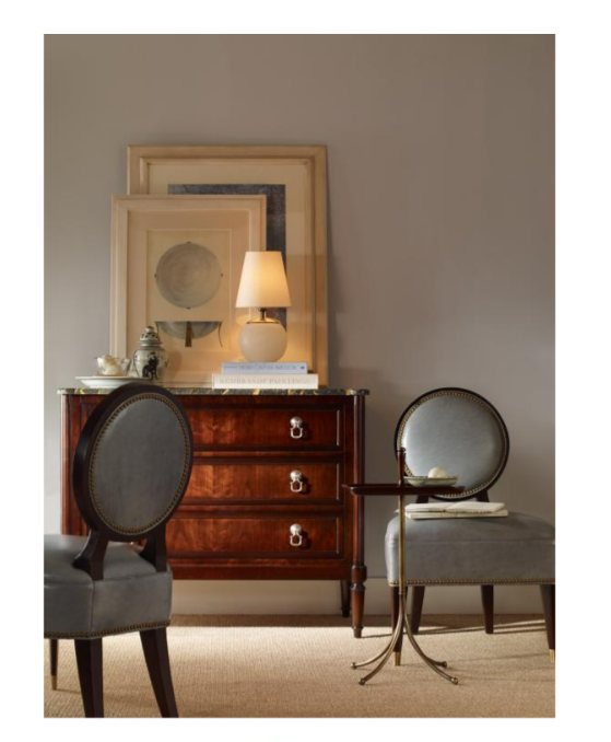 A curated furniture vignette with a mahogany chest and oval-back chairs