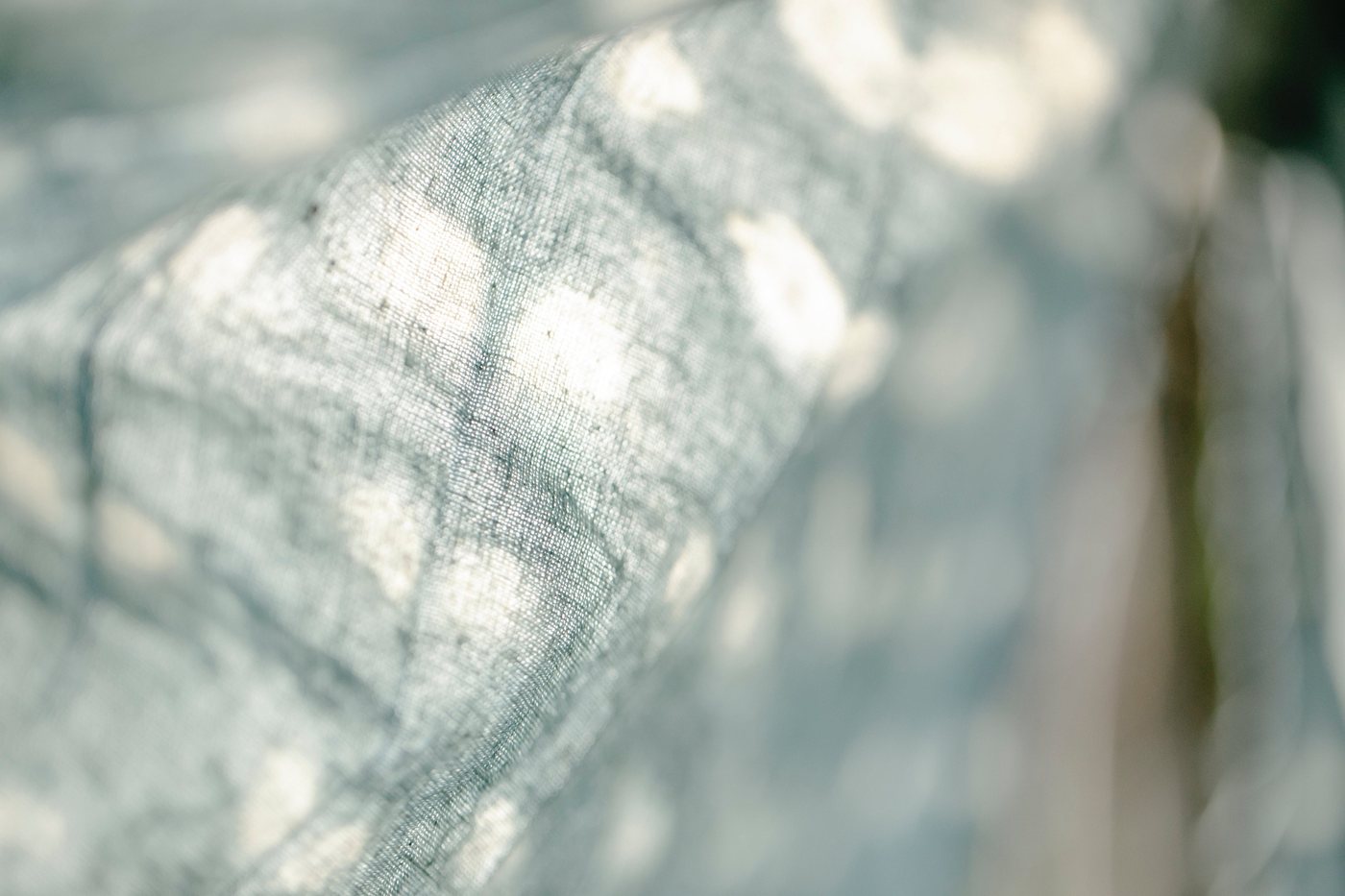 Dappled light through a custom sheer linen window treatment.