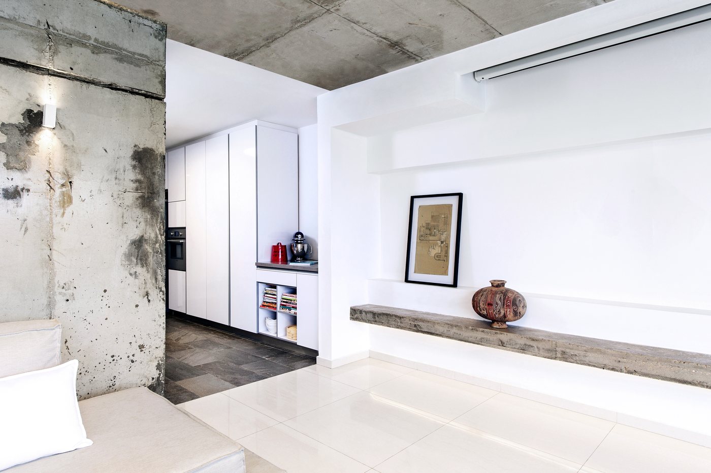 Raw concrete meets crisp white in a minimalist industrial loft living space.